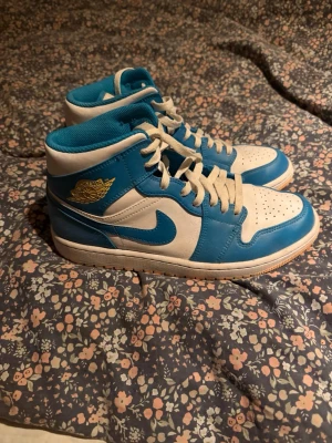 Nike Air Jordan 1 aquatone - Säljer ett par Nike Air Jordan 1 Mid sneakers i väldigt bra skick, jag har aldrig använt dom, dom har stått hemma i 1 år därför snörena ser smutsiga ut för dom har samlat på sig dam, men fixar de såklart innan de skickas. Mvh Liam storlek 42.5 priset ej hugget i sten