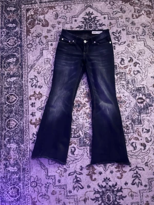 bootcut jeans - Säljer ett par mörkblå bootcut jeans från bershka. Slitna längst nere. Kommer inte tvätta innan.