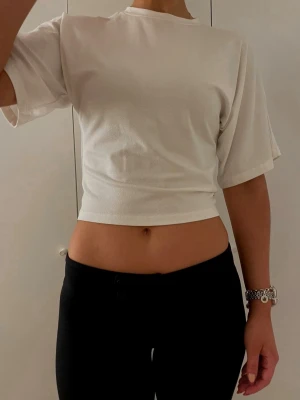 Vit croppad t-shirt - En enkel och stilren vit croppad t-shirt med rund hals och korta ärmar. Perfekt basplagg som är lätt att matcha till olika outfits. Tillverkad i mjukt bomullsmaterial för en bekväm känsla. 🩷
