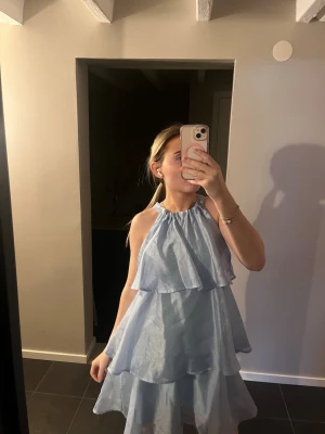 Ljusblå volangklänning  - Supersöt ljusblå kortklänning med volanger och knyt i nacken. Använd en gång🫶