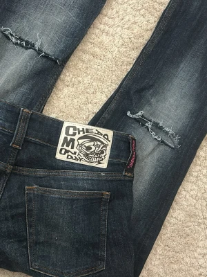 Mörkblå slitna Cheap Monday jeans - Säljer ett par mörkblå jeans från Cheap Monday med slitningar och fransiga hål på benen💕
