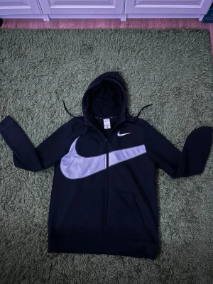 Svart Nike tracksuit  - Snygg svart hoodie från Nike med dragkedja. Tillverkad i Dri-FIT-material. Det säljs tillsammans, i storlek M