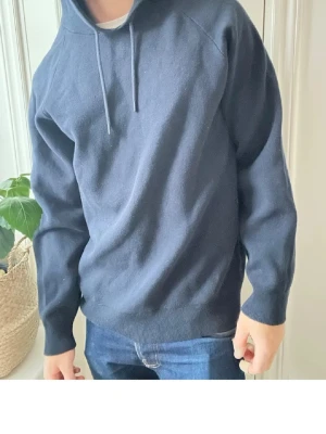 Mörkblå hoodie från Selected Homme - Snygg mörkblå hoodie från Selected Homme med klassisk huva och dragsnören. Tillverkad i mjukt material som känns skönt mot huden. Perfekt till jeans eller joggers för en avslappnad look.