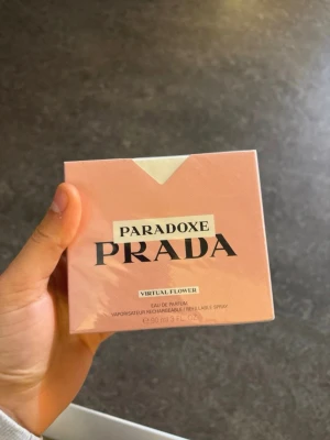 Prada Paradoxe Virtual Flower EdP - Prada Paradoxe Virtual Flower Eau de Parfum är en exklusiv parfym i en elegant, ljusrosa förpackning med modern design. Doften är blommig och kommer i en praktisk 90 ml refillbar sprayflaska. Perfekt för dig som gillar lyxiga och trendiga dofter.