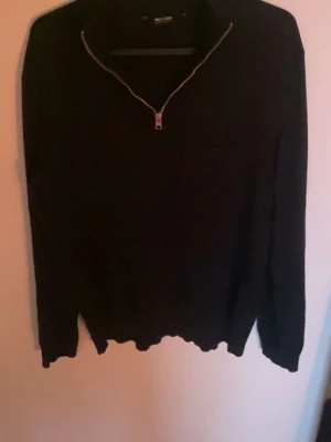 Svart halfzip från Only & Sons - Snygg svart stickad tröja från Only & Sons med halv dragkedja framtill. Tröjan har lång ärm och ribbade muddar vid ärmslut och nederkant. Perfekt till höst och vinter för en stilren look. 