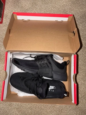 Nike Air Presto Triple Black sneakers - Säljer ett par helt nya Nike Air Presto Triple Black sneakers. Skorna är helsvarta med mesh-överdel, plastdetaljer vid snörningen och en bekväm sula. Klassisk Nike-logga på plösen och hälen. Perfekta för dig som gillar stilrena och sportiga sneakers.☀️