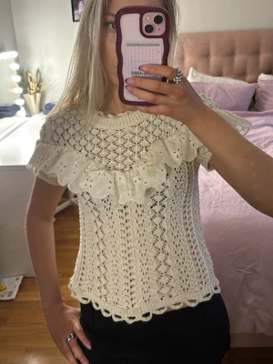 Beige stickad topp med volang - Supersöt stickad topp med spetsmönster och bred volang. Säljer då den inte kommer till användning💞