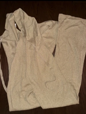  glittrig jumpsuit & Other Stories  - Supersnygg beige jumpsuit med glittrigt tyg och vida ben från & Other stories