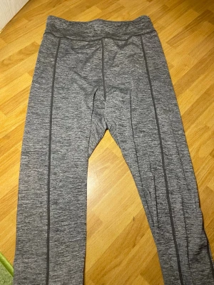 Gråmelerade leggings set från Cubus - Snygga gråmelerade leggings set från Cubus BASIC med svarta sömdetaljer längs benen. Stretchigt material som sitter skönt och följer kroppen. Perfekta till både träning och chill. Midjehög modell och mjuk känsla.