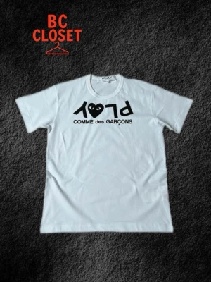 CDG Play t shirt  - Säljer denna T-shirt ifrån Comme Des Garçon då den inte passar mig, med det billiga priset då trycket har slitits efter att ha råkat tvättats i för hög värme. Fortvarande ett värt köp med tanke på det låga priset! Vill bara bli av med tröjan. Storlek S, skriv för frågor!