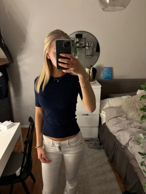 Mörkblå tight stickad topp - Snygg mörkblå stickad topp med korta ärmar och rund halsringning. Modellen är tight och passar perfekt till både jeans och kjol. Enkel och stilren design som är lätt att matcha.