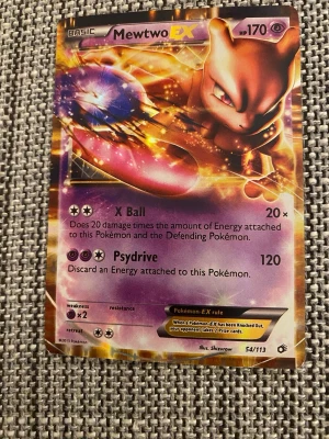 Pokémonkort Mewtwo EX 54/113 - Säljer ett Pokémonkort med Mewtwo EX från serien Black & White Next Destinies, nummer 54/113. Kortet har en färgstark och glansig design med lila, guld och orange toner. Engelskspråkig text och holografisk yta. Perfekt för samlare eller Pokémonfans.