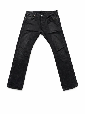 Levis 501 - Säljer ett par svarta jeans från Levi's med klassisk femficksdesign och raka ben. Jeansen har knappgylf och diskreta slitningar för en cool look. Tillverkade i bomull med en bekväm passform. Perfekta till vardagsstilen! I storlek 34/32