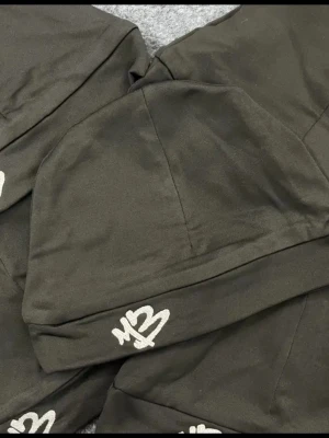 Svart mössa med M3-brodyr - Snygg svart mössa med vit M3-brodyr framtill. Tillverkad i ett stretchigt och mjukt material som sitter skönt på huvudet. Perfekt för dig som vill ha en stilren och enkel accessoar med en touch av streetstyle.