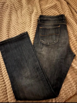 Mörkblå Lee jeans med raka ben - Snygga mörkblå jeans från Lee med klassisk femficksmodell och raka ben. Jeansen har kontrastsömmar och en Lee-logga på bakfickan samt läderpatch i midjan. Tillverkade i slitstark denim som passar perfekt till vardagslooken.