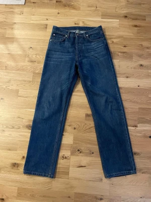 Djerf Avenue relaxed jeans  - Djerf avenues relaxed jeans i färgen mörkblå. 100% bomull vilket gör att de stretchar sig lite med tiden. Använda ca 1-2 gånger men känns helt nya. Boyfriend fit/straight.                                                       Storlek 26, motsvarande svensk storlek 36. Nypris: 1500 (se storleksguide i bilderna) se passform på hemsidan:    https://djerfavenue.com/sv-se/relaxed-jeans-dark-blue/