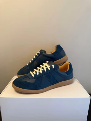 Oliver Cabell GATS - Säljer ett par Oliver Cabell GAT i storlek 43. Endast testade inomhus – aldrig använda ute. I princip nyskick (10/10).  Handgjorda i premium italienskt läder och mocka med klassisk minimalistisk design. Väldigt clean och lyxig modell som passar både dressat och casual. Utmärkt för ett annat alternativ på Maison Margielas gats  • Storlek 43 (true to size) • Nyskick • Originalbox medföljer • Nypris ca 2000 kr • Navy/Blå  Säljes till bra pris vid snabb affär ✨ Skickas snabbt och säkert.