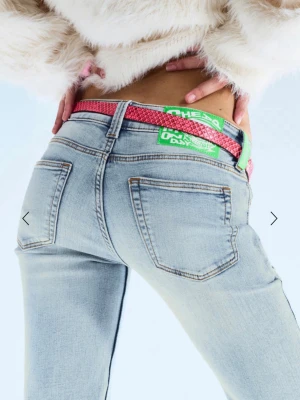 Ljusblå bootcut jeans med slitningar - Säljer ett par ljusblå bootcut jeans med snygga slitningar framtill och klassiska bakfickor. Jeansen har låg midja och är tillverkade i stretchigt denim för skön passform. Perfekta för en trendig och avslappnad look.