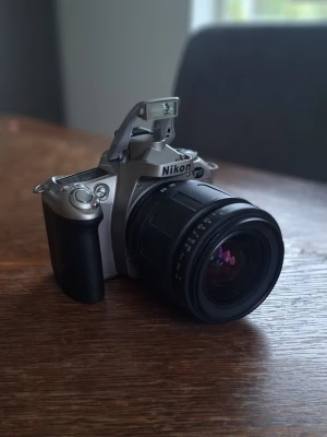 Nikon F55 Analog + tillbehör  - Säljer min Nikon F55, en analog kamera som använder vanlig 35mm film, alltså inte digital. Kameran är i gott skick utan synliga repor eller skador. Passar perfekt för dig som vill fota på ett vintage sätt eller gillar vintage kameror. Medföljer  Tamron 28-70mm zoomobjektiv Tamron filter 62mm Övriga tillbehör  Fråga mig gärna, om du undrar!
