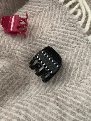 Unik hårklämma - Säljer en svart hårklämma med glansig finish och diamantmönstrad yta. Klämman har ett bra grepp och håller håret på plats. Perfekt accessoar för att snabbt fixa frisyren. 