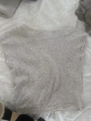 Ljusgrå stickad topp från Nelly - ”offshoulder” stickad kortärmad tröja i beige färg från Nelly. Knappt använd i storlek M