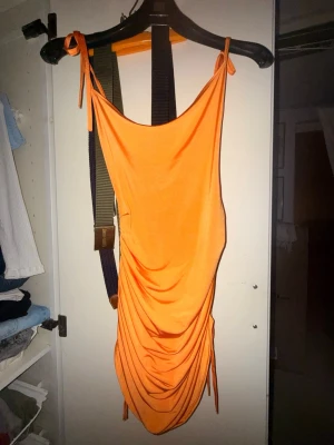 Orange miniklänning  - Superfin orange klänning med scrunch på sidorna, det går att ha den både som miniklänning och som långklänning genom att släppa på snörerna på scrunchen🧡🧡