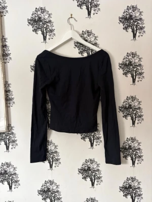 Navy långärmad croppad topp - En stilren Navy långärmad topp med cro head och bred urringning. ‘Offshoulder’-känsla och figurnära passform som ger en snygg siluett. Perf bi till jeans eller kjol för en net look. Tillverk adjustments i mjuk bom finished.