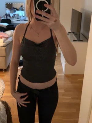 f - Snygg glitter topp med tunna axelband och öppen rygg och sitter tight mot kroppen. 