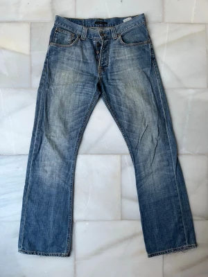Blå Nudie Bootcut jeans - Regular Ralf - Säljer ett par extremt feta Nudie Jeans i modellen Regular Ralf som är väl bevarade i storleken 32-32. Nudie Jeans slutade sälja Regular Ralf 2010 så dessa jeans är över 16 gamla men fortfarande i ett väldigt bra skick och svåra att få tag i. Kontakta mig vid minsta fundering! 😊✌🏼