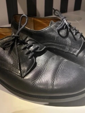 Skor i läder från J.P.W. - Eleganta svarta läderskor från J.P.W. Klassisk design med snörning och en bekväm läderinnersula. Perfekt för både formella och vardagliga tillfällen. Mycket sparsamt använda (Bröllop, dop & begravning typ). Storlek 41
