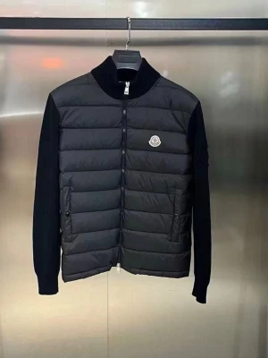 Svart dunväst från Moncler - Snygg svart dunväst från Moncler med quiltad front, ribbad krage och ärmar i kontrasterande material. Västen har två fickor med dragkedja och Moncler-logga på bröstet. Perfekt för dig som vill ha en stilren och exklusiv look.