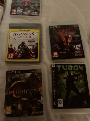 PS3 spelpaket med action och äventyr - Säljer ett paket med PS3-spel som inkluderar Assassin's Creed II, Resident Evil: Operation Raccoon City, Lost Planet 2, Turok, Killzone 3, Homefront, Rage, Battlefield 3, Resistance: Fall of Man och Aliens Colonial Marines. Perfekt för dig som gillar action, äventyr och shooters. Spelen har färgstarka omslag och är i plastfodral.