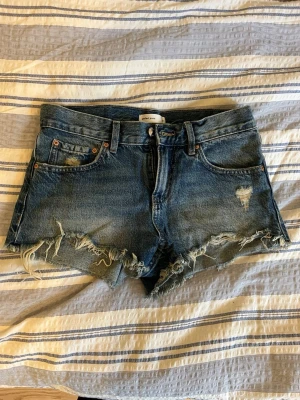 Jeansshorts  - Jättesnygga jeansshorts med hål och slitningar på inför sommaren! Från Gina Tricot i stl 32. Används fåtal gånger men syns ej på dem 