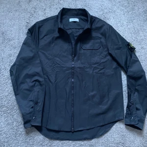 Stone Island jacka  - Snygg svart overshirt från Stone Island med dragkedja, perfekt för dig som vill ha lite av en clean look. Köptes originellt i Amsterdam.