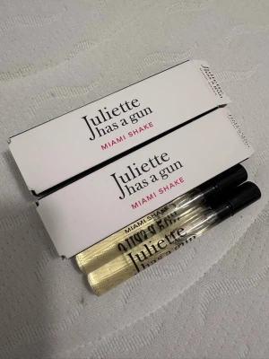 Juliette Wilson Miami Shake parfym - Två smidiga parfymprover från Juliette has snug i doften Miami Shake. Flaskorna är genomskinliga med svart quot; och text i svart och rosa. Perfekt att ha i väskan för en fräsch doft när som helst.