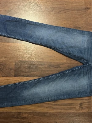 Blå skinny jeans med slitningar - Säljer ett par blå skinny jeans med lätt slitna detaljer och klassisk femficksdesign. Jeansen har normalhög midja och smala ben. Perfekta till sneakers eller boots och gjorda i mjukt denimtyg för skön passform. Kan diskutera pris 
