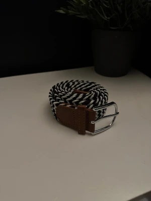 Flätat bälte svart vitt  - Ett riktigt snyggt flätat bälte. Bältet är svart vitt och passar till det mesta. Skicket är otroligt bra då de endast är använt någon enstaka gång. Skriv vid frågor och kolla gärna in min profil för fler bälten och kläder!