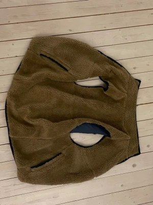 Brun teddyväst från Levi's - Mysig brun teddyväst från Levi's med mjuk fleece på utsidan och mörkblått foder. Västen har två fickor med dragkedja och klassisk passform. Perfekt för lager-på-lager och chill stil.