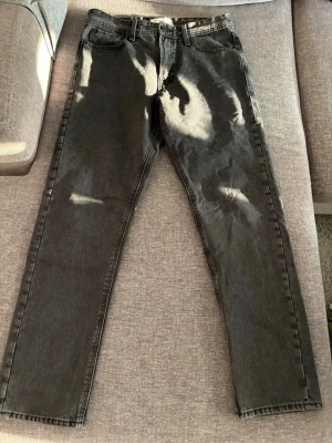 Svarta jeans från Stock & Hank - Snygga svarta jeans från Stock & Hank med klassisk femficksdesign och raka ben. Jeansen är i denim och har en stilren look som passar till det mesta. Perfekta för dig som gillar en enkel och tidlös stil.