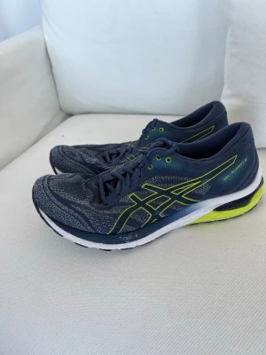 Asics blå sneakers med neongula detaljer - Bra för gym, springa eller om man bara vill ha en skön sko. Passar storlek 44! Nypris: 1000-1500kr 