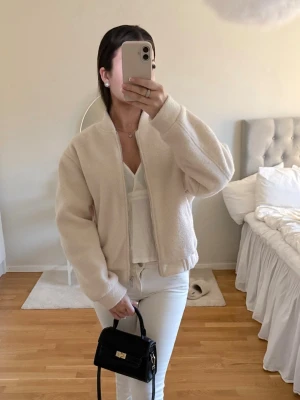 Ljus rosa teddyjacka - Säljer en ljus rosa teddyjacka med dragkedja i storlek S. Jackan har en enkel, stilren design utan synliga fickor och är gjord i mjukt, fluffigt material. 🤍