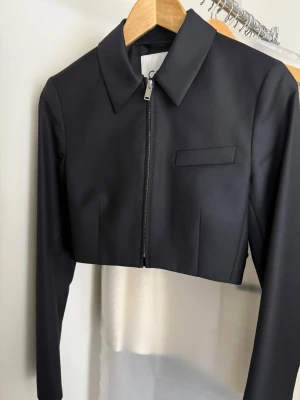 Svart cropped kavaj med dragkedja i ull, COS, strl xs - I mycket fint skick (72% ull och 28% polyester)