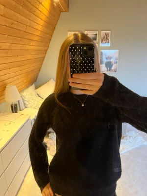 Svart stickad tröja - Mysig svart stickad tröja med rund hals och långa ärmar. Tröjan har en enkel och stilren design, perfekt att matcha med olika outfits. Materialet är väldigt mjukt och mysigt. För referens 172 cm lång. Priset kan diskuteras 