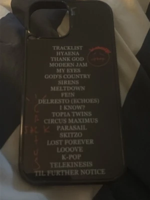Svart mobilskal med albumtracklist - Coolt svart mobilskal med vit text som visar en tracklist från ett album med travis Scott