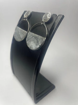 Stora silverfärgade cirkelörhängen - Säljer ett par stora, trendiga örhängen i silverfärg med rund form. Örhängena har en halvcirkel i frostat material som ger en cool kontrast till den blanka metallen. Perfekta för dig som gillar statement-smycken och modern design.