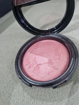 Flormar Baked Blush Shimmer Pink - Baked blush från Flormar i färgen Shimmer Pink. Rouget har en rund, kupolformad yta och kommer i en svart kompakt förpackning med spegel. Ger ett skimrande rosa resultat och är perfekt för att skapa en fräsch look.