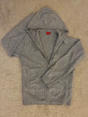 Grå hoodie med dragkedja från RYVLS - Klassisk grå hoodie från RYVLS med dragkedja framtill och huva. Tillverkad i mjuk bomullsmix och har långa ärmar, Perfekt för en chill och avslappnad stil. Hoodien i storlek 164cm men passar till ca170-175cm och är i perfekt skick✅ Fraktar inom en dag✅ Priset är inte hugget i sten🙂