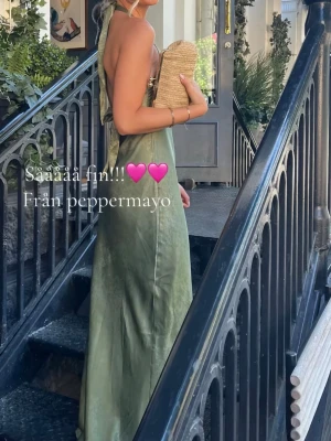 Grön balklänning  - Säljer en elegant grön balklänning från Peppermayo i satinliknande material. Klänningen har öppen rygg, halterneck och en slim passform som ger en snygg siluett. Klänningen är helt ny lappen sitter fortfarande kvar, säljer den på grund av att jag har hittat en annan! Pris kan diskuteras. Färgen kan se annorlunda ut på bilderna men första bilden på tjejen är den exakta färgen. Kan skicka bild också… 