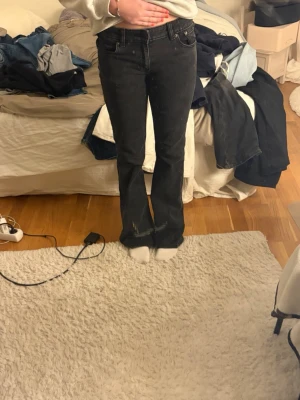 Svarta bootcut jeans med hög midja - Säljer ett par svarta bootcut jeans med hög midja och klassisk femficksdesign. Jeansen har en lätt utsvängd passform nedtill och är tillverkade i ett mjukt denimtyg. Perfekta för dig som gillar en tidlös och avslappnad stil.