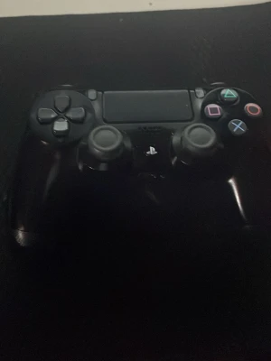 Svart PlayStation 4 DualShock kontroll - Säljer en svart PlayStation 4 DualShock handkontroll från Sony. Den har klassiska symbolknappar i färg, två analoga spakar, styrkors och touchpad. Perfekt för gaming på PS4 och har en skön ergonomisk form i plast.